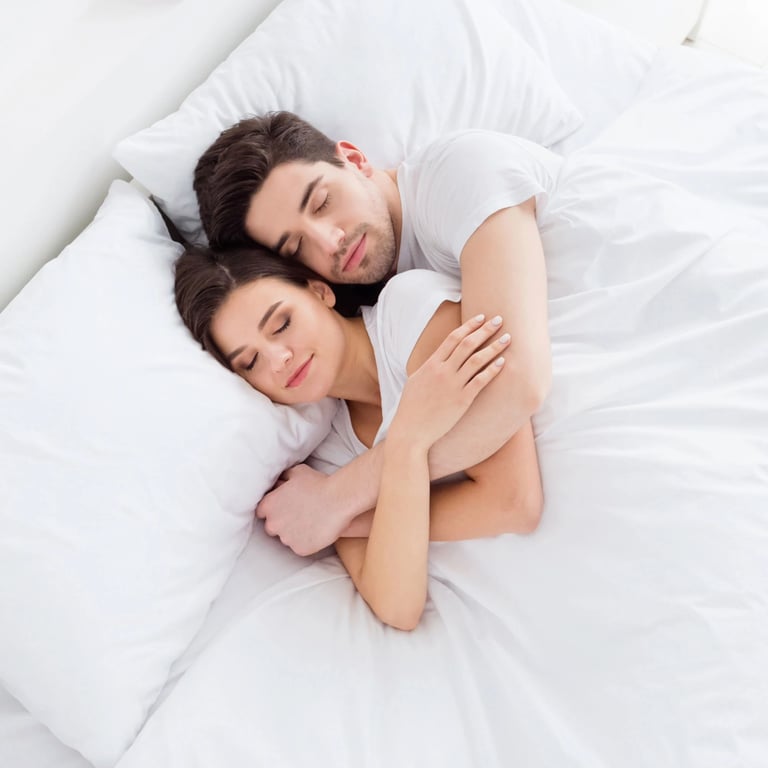 Pärchen umarmt sich im Bett liegend