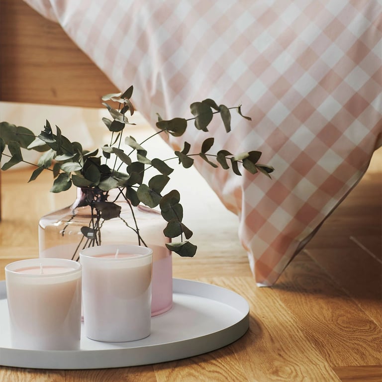 Auschnitt von zwei Kerzen auf einem Tablet; neben einem Bett stehend