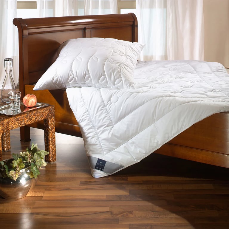 Kissen und Bettdecke ohne Bezug auf einem Bett