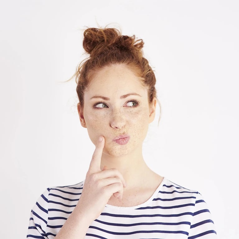 Frau hält Zeigefinger an Backe und macht ein überlegendes Gesicht